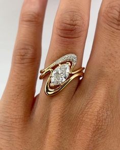 a woman's hand with a gold and diamond ring on top of her finger