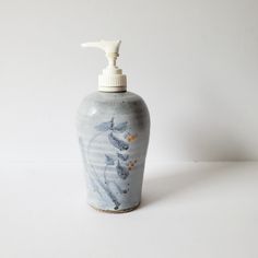 a hand soap dispenser with flowers painted on it