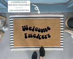 a welcome rug with the words,'welcome fudgers'on it next to shoes