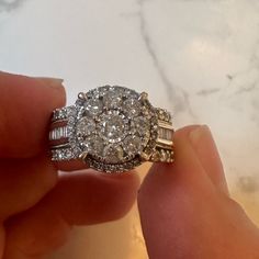 a person holding an engagement ring in their hand with two diamonds on the top and bottom