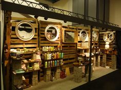 several wooden shelves with different types of items on them and some lights hanging from the ceiling