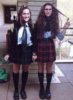 two girls dressed in school uniforms standing next to each other