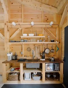 a kitchen area with wooden walls and shelves