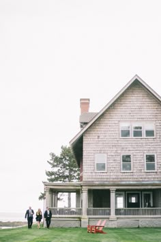 two people walking towards a house on the grass