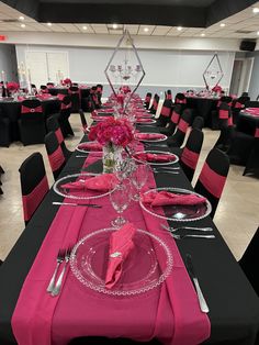 the tables are set with black and pink linens, silverware, and flowers