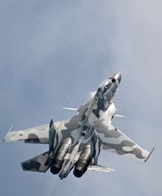 a camouflaged fighter jet flying in the sky