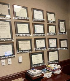 a wall with many framed papers on it