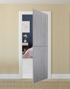 an open door to a bedroom with a bed in the background