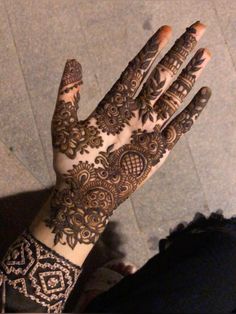 a woman's hand with henna tattoos on it