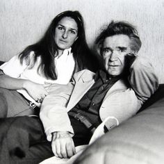 black and white photograph of two people sitting on a couch, one is holding the other's arm