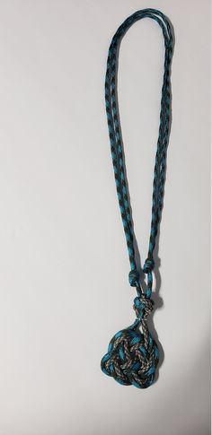 a blue and black rope with a bell on it's end hanging from a hook