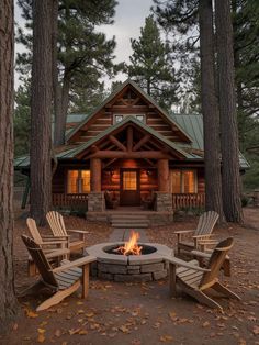 a fire pit in front of a cabin surrounded by trees