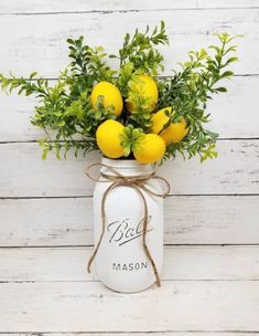 a mason jar filled with lemons and greenery