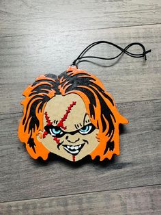 a wooden ornament with an image of a clown's face on it