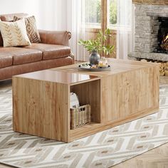 a living room with a couch, coffee table and fire place in the center area