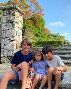 three children sitting on steps with a skateboard