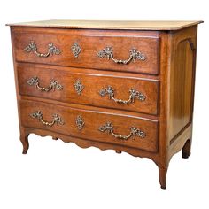 an antique chest of drawers with brass handles