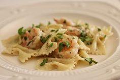 a white plate topped with pasta and shrimp