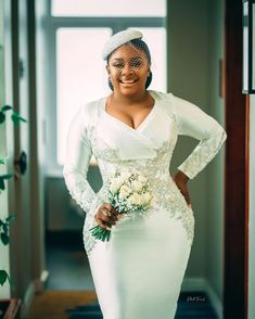 a woman in a white dress and veil smiles at the camera as she poses for a photo