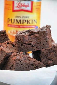 chocolate brownies in a white bowl next to a can of pumpkin