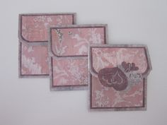 three pink and white cards with designs on them