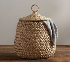 a large woven basket with a blue towel on the top and bottom, sitting on a wooden table