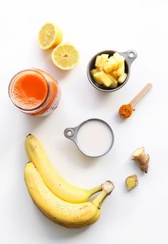 bananas, orange juice and other ingredients on a white surface