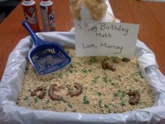 a teddy bear sitting on top of a birthday cake made to look like it is in the sand