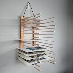 a wall mounted book shelf with several books on it and a light hanging from the ceiling