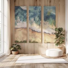 three paintings hanging on the wall next to a potted plant in front of a window