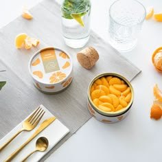 orange slices in a bowl on a table with utensils and other food items