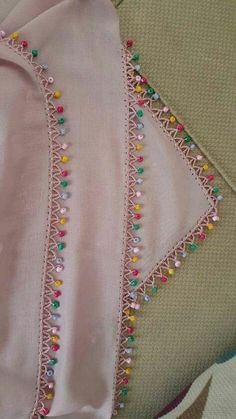 a pink cloth with beaded trim on it