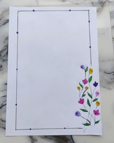 a piece of paper with flowers on it sitting on a marble counter top next to scissors