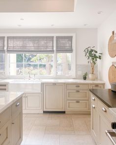 a large kitchen with white cabinets and marble counter tops