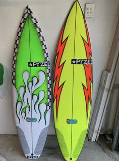 two surfboards sitting next to each other in a garage