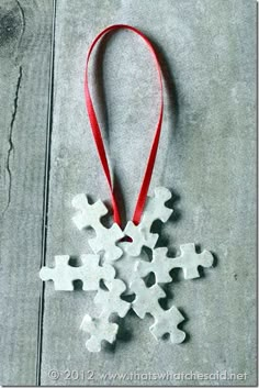 a snowflake ornament hanging from a red ribbon