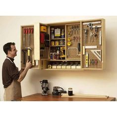 a man holding a cabinet with tools in it