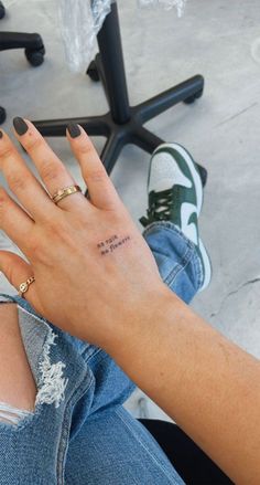 a woman's hand with a small tattoo on it