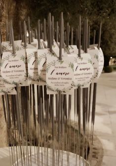 there are many tags hanging from the poles on this tree stumps that have been decorated with pine cones and leaves