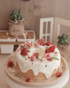 a cake with white frosting and strawberries on top