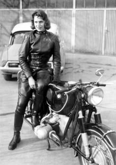 a woman sitting on the back of a motorcycle