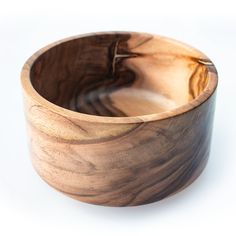 a wooden bowl sitting on top of a white table