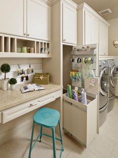 a washer and dryer in a room with white cabinets, counter tops and stools