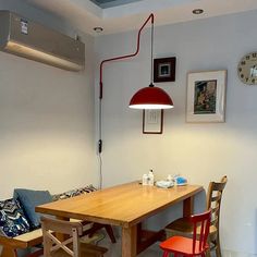 a kitchen table with chairs and a lamp hanging from the ceiling in front of it