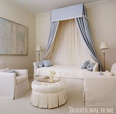 a living room with white furniture and curtains