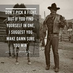 a man standing next to a horse on top of a dirt field