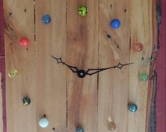 a clock made out of wooden boards with different colored knobs on the face and hands