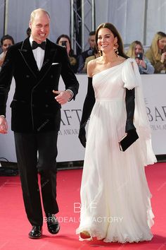 a man in a tuxedo walking next to a woman in a white dress