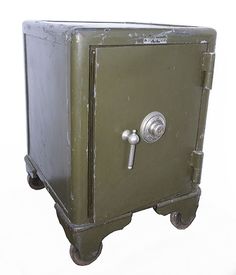 an old green metal cabinet with wheels and knobs on the door is shown against a white background