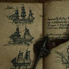 an open book with drawings on it and a pair of old scissors in the middle